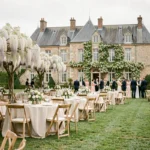 Vue panoramique d'une salle de mariage de prestige dans les Yvelines avec château en arrière-plan et tables décorées sur pelouse