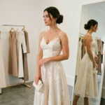 Femme essayant une robe de mariage civil élégante en ivoire dans une boutique moderne et minimaliste