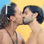 two men with long hair are kissing each other