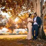 couple kissing under brown tree during daytime