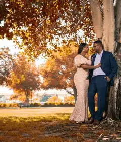 couple kissing under brown tree during daytime